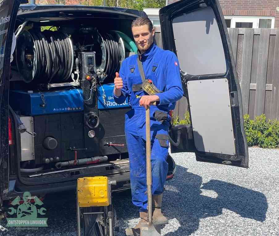 Een tevreden monteur met opgestoken duim naast de bestelbus, slim ingrijpen bespaart kosten bij een verstopte afvoer in IJmuiden