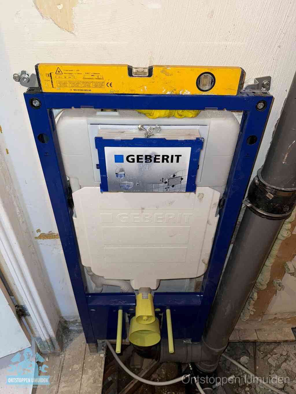 Een Geberit inbouwreservoir met frame voor een hangtoilet tegen de wand, met de afvoerbocht naar de vloer, kenmerkend voor een verstopt hangtoilet in IJmuiden
