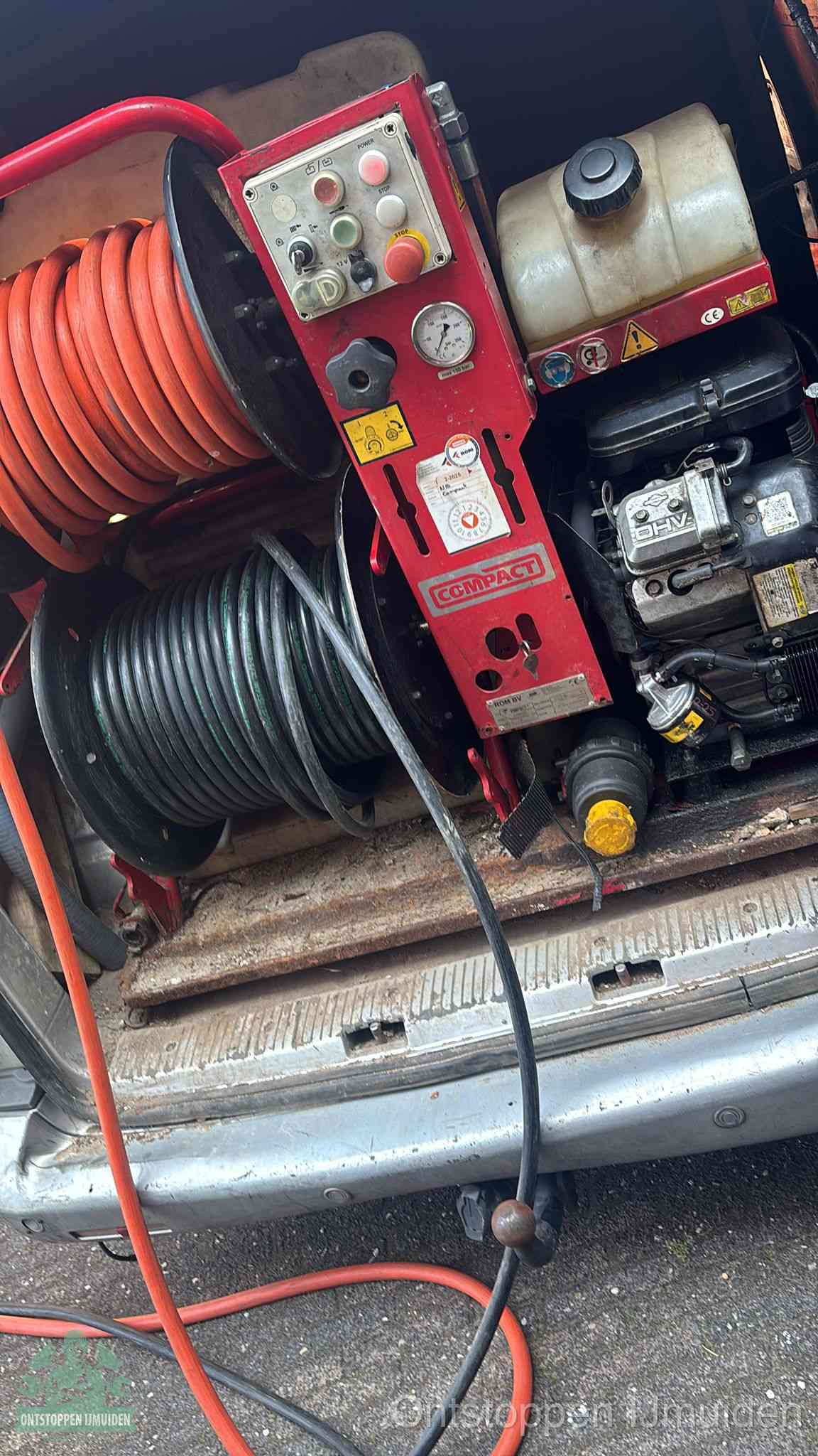 Een rood hogedruk-rioolreinigingstoestel in de laadbak van de bedrijfsbus, apparatuur voor een hardnekkige afvoerverstopping in IJmuiden