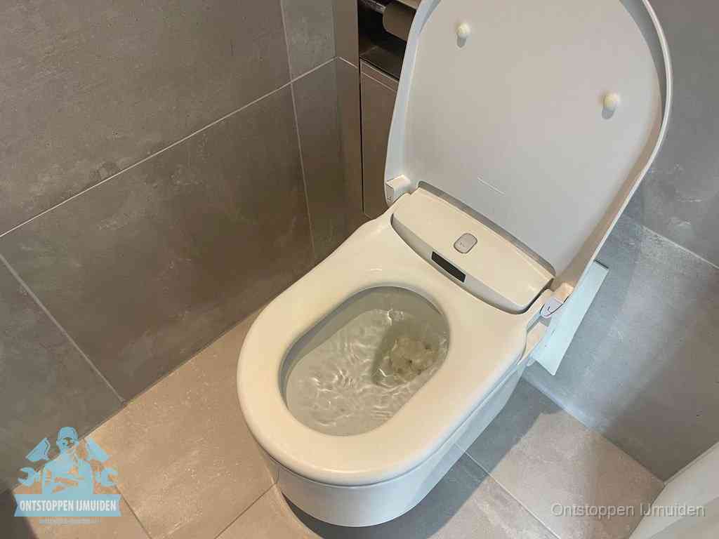 Een toiletpot vol troebel water met drijvend papier en restanten, de meest voorkomende oorzaak van een verstopte wc in IJmuiden