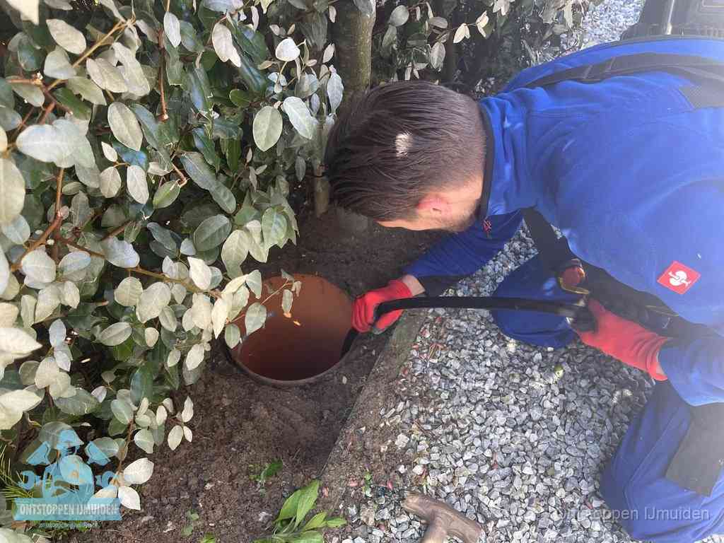 Monteur reinigt een rioolput met een slang, periodieke rioolreiniging in IJmuiden