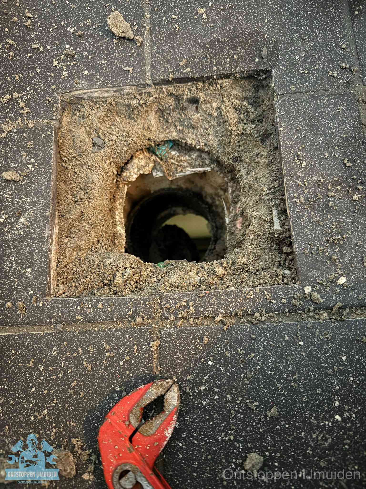 Geopend rioolputje op de erfgrens dat laat zien wie eigenaar is van de riolering in IJmuiden