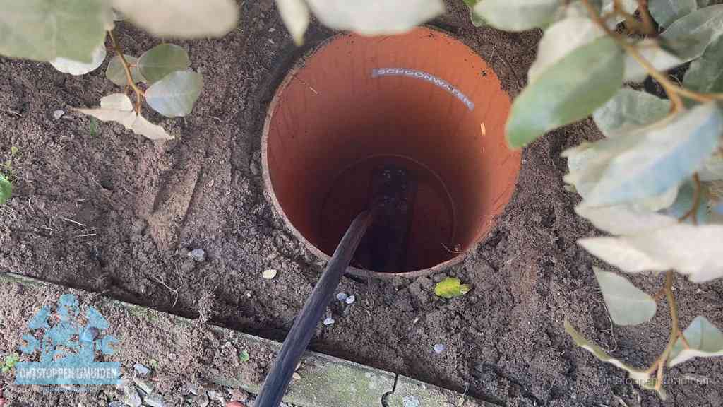 Open inspectieput in de tuin waar een veer rioolvliegjes en stankoverlast aanpakt in IJmuiden
